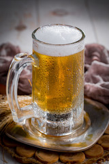 Light beer in a glass, on an old background.