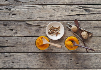 Health benefits of pumpkin. Pumpkin pulp is passed through a blender. Natural smoothie made at home on a natural wooden table. Place for text.Top view.