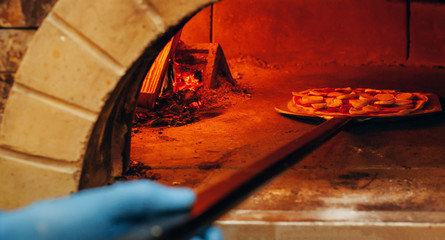 Italian pizza is cooked in a wood-fired oven