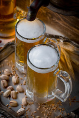 Light frothing beer in a glass, on an old background.