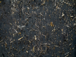 The surface texture of the old black wood particle board.