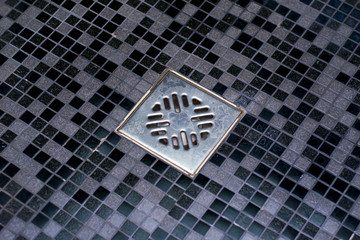 shower drain in a stone dark gray bathroom