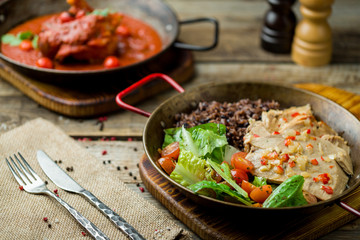 Turkey with black rice on old wooden table
