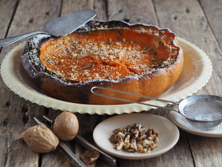 Pumpkin Background. Baked pumpkin sprinkled with ground walnuts, on a wooden ancient background with ingredients. Place for text.