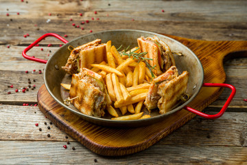 club sandwich with fries on wooden table