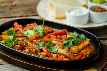 Fajitas with beef on wooden table