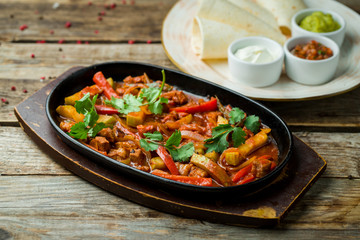 Fajitas with beef on wooden table