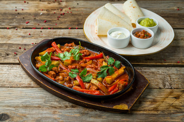 Fajitas with beef on wooden table
