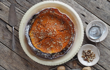 Pumpkin Background. Baked pumpkin sprinkled with ground walnuts, on a wooden ancient background with ingredients. Place for text.