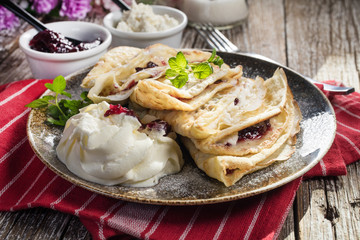 Crepes with ricotta cheese and blackcurrant jam.