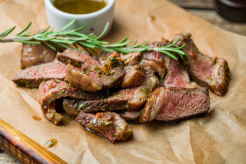 Beef steak sliced on the board on old wooden table