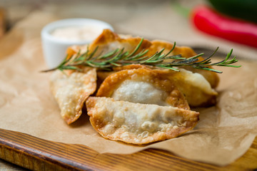 fried mini chebureks on old wooden table