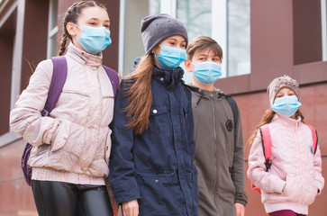 Fototapeta na wymiar city residents adults and children observe quarantine and go in masks.