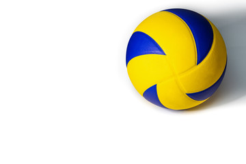Closeup yellow blue volleyball sports equipment with light shining from the front, with shadow on the back, isolated leather volley ball object and copy space on a white background