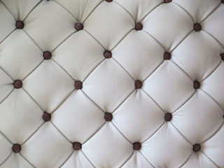 White leather upholstery with a carriage tie.