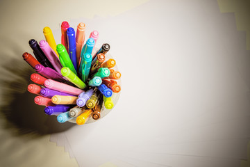 Top view group multicolor pen combine in a small plastic pot on a neatly arranged sheet of paper for write text copy space on old background vintage style