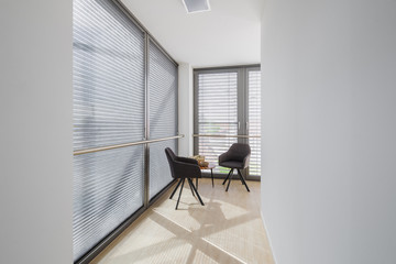 Two stylish grey chairs standing at the hall of modern building