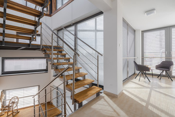 Interior with wooden stairs and large windows