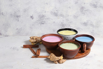 An assortment of colorful latte Japanese tea, golden turmeric, matcha, blue, pink moon milk. It has...