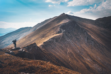 Hiking trough epic mountain landscape with a big backpack, exploring and feeling the freedom of nature