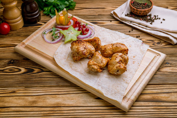 chicken kebab on board on wooden table