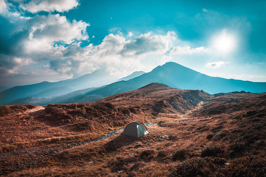 Hiking trough epic mountain landscape, camping in a tent, exploring and feeling the freedom of nature