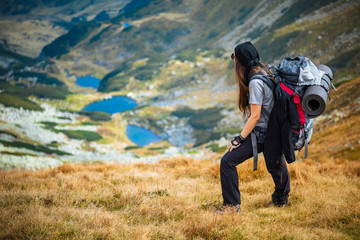 Fototapeta na wymiar Hiking trough epic mountain landscape with a big backpack, exploring and feeling the freedom of nature