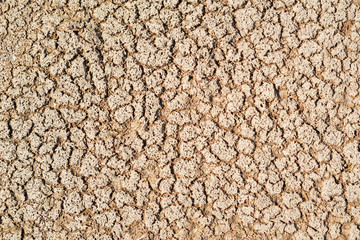 Part of a huge area dried land suffering from drought-in cracks. Dry water reservoir. Dry clay soil texture in the ground