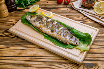 Fried sea bass on wooden table