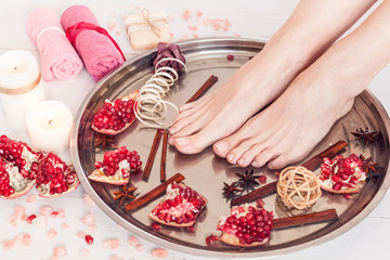 pedicure in the spa salon with pomegranate, cinnamon and anise