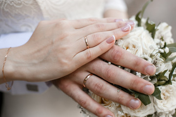 Obraz na płótnie Canvas hands of the bride and groom on a wedding bouquet