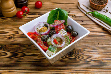 Greek salad with feta on wooden table