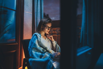 Home Office, Young businesswoman working remotely during quarantine from home late at night using laptop computer, Young woman entrepreneur in eyeglasses using portable computer sending monthly report