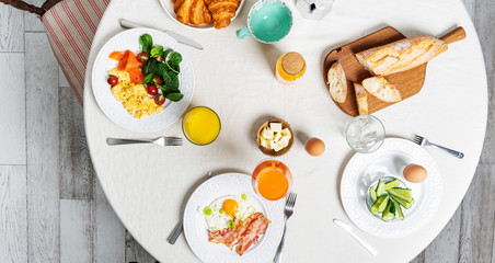Healthy breakfast with different cooked eggs, coffee. Flat-lay of plates with food over white textile round table background, top view. stay home.