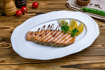 Salmon steak on the grill on wooden table