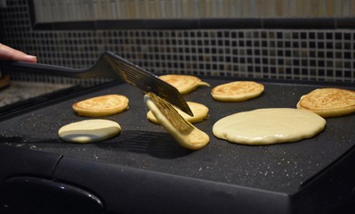 A pancake being flipped by a spatula action shot