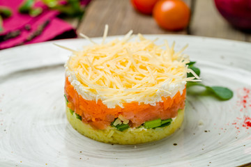 Mimosa salad on a plate on wooden table