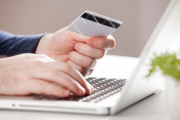Man holding credit card and using laptop. Online shopping concept