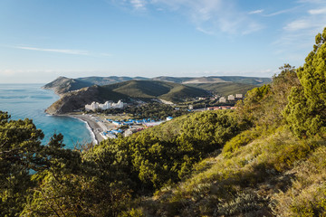 View of the resort village of Sukko in Russia from Mount Soldatskaya covered with juniper forest. The beginning of the Caucasus Range. Valley at the Black Sea.