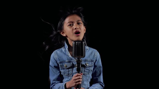 A little asian girl sings in the wind