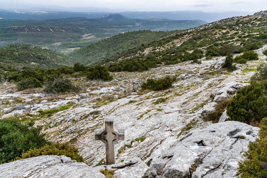 The sacred cross St.Pilon is on the mountain in cloudy weather, clouds over a valley, a dry grass, mountain over grotto of Mary Magdalene