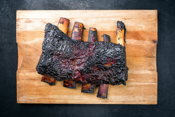 Barbecue burnt chuck beef ribs marinated with hot chili sauce as top view on an old rustic wooden...