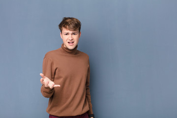young blonde man looking angry, annoyed and frustrated screaming wtf or what‚Äôs wrong with you...