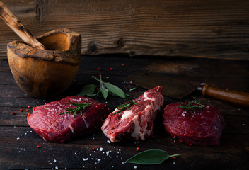 Fresh raw beef steaks on wooden board