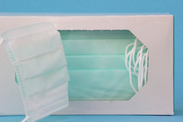 Medical masks or protective masks are in the packaging and ready to use. Light blue background.