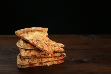 pieces of pizza stacked on brown wood table