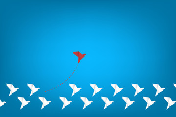 Think differently concept. Be different. Red bird changing direction. New idea, change, trend, courage, creative solution, innovation and unique way concept	