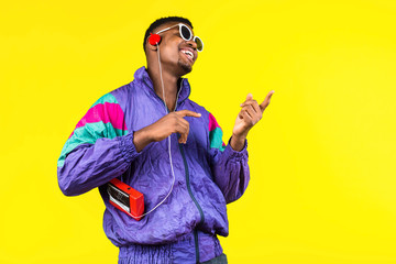 African American young man, in a jacket in the style of the 90s, with a retro cassette player,...
