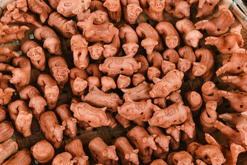 Background of unpainted clay animals in a street market. Pattern of brown ceramic figures