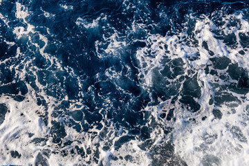 Top down aerial view of sea water surface. White foam waves texture as natural background.